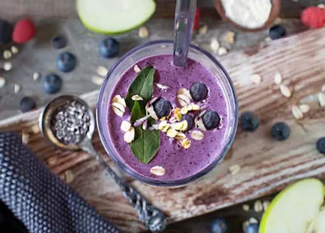 Top view of homemade protein smoothie with berries and protein powder.