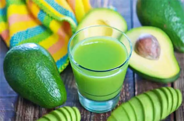 Yummy avocado smoothie surrounded by avocados.