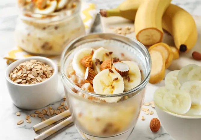 Stacked banana smoothies with fresh bananas and oats.