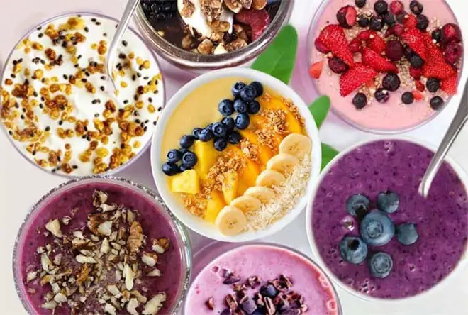 Top view of assorted frozen fruit smoothies with toppings.