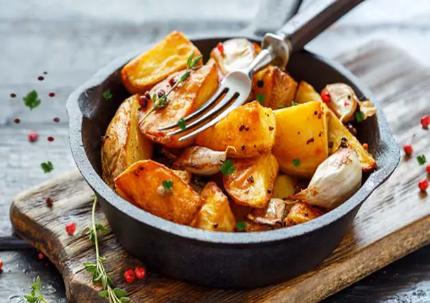 Delicious homemade potato wedges in a cast iron pan.