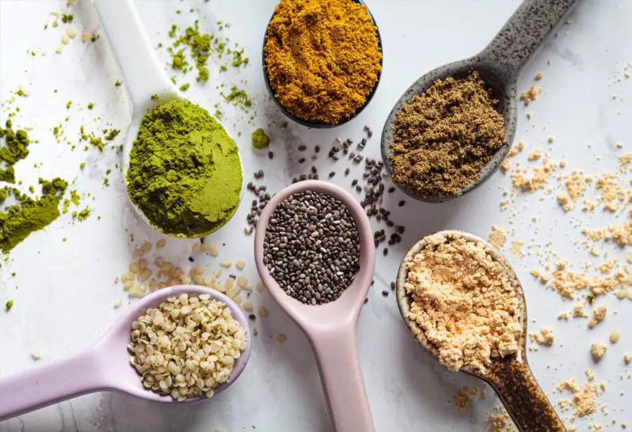 Heaping spoons of powdered superfood blends and seeds. 