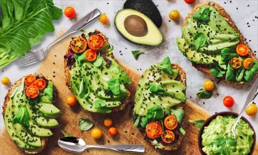 An array of avocado toasts on a board.  