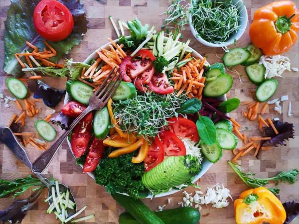 A huge colorful salad displays a vegan recipe and healthy lunch idea. 