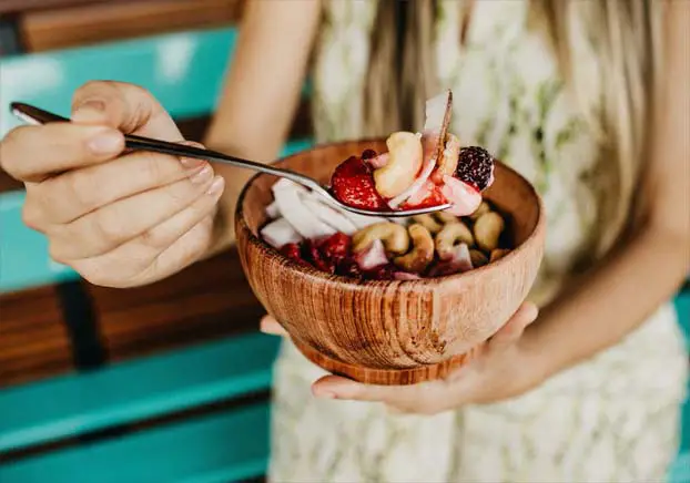 Girl holding up a bowl of vegan granola.