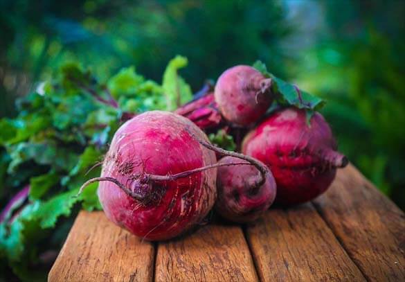 Giant beetroot bulbs on a board. 