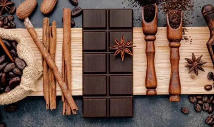 Top view of dark chocolate, cinnamon, and coffee beans. 