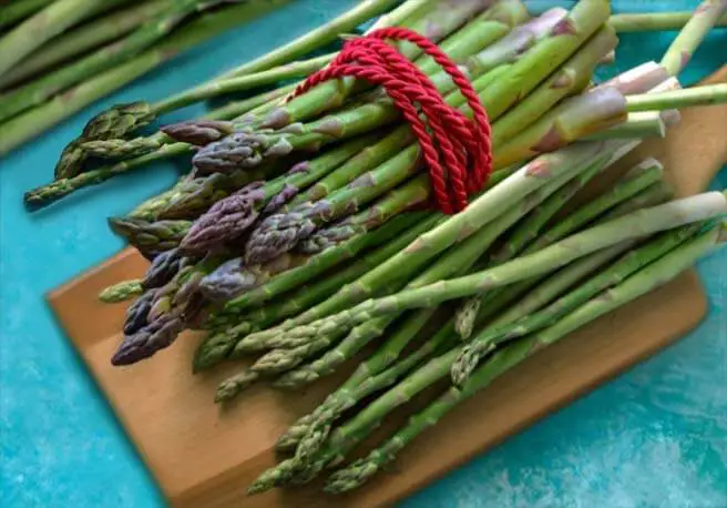 Bunches of fresh green asparagus on a board. 