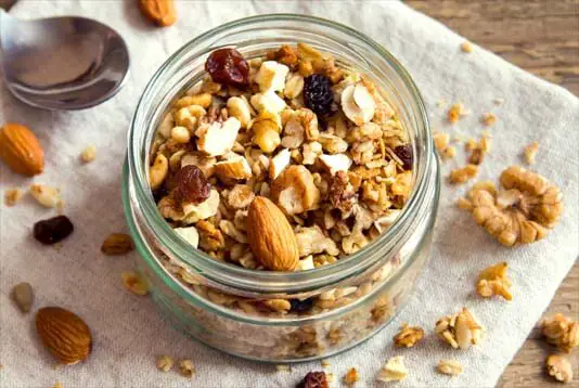 Top view of open jar of homemade granola. 