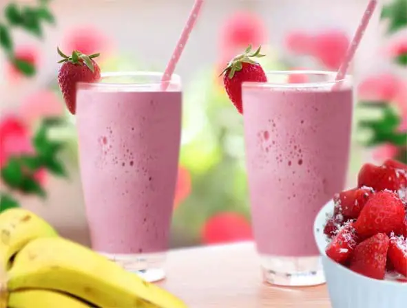 Two vegan strawberry banana smoothies with fresh strawberries & bananas. 