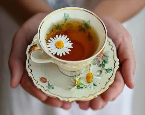 Top view closeup of a mug of tea in cupped hands.   