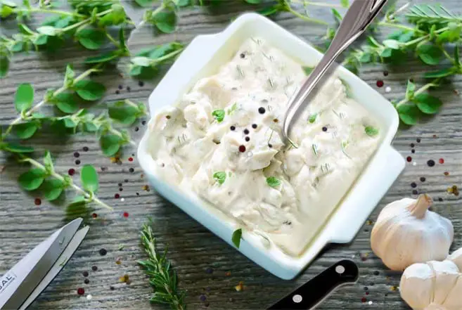 Top view of garlic mashed potatoes and herbs. 