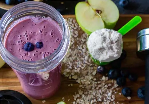 Top view of protein smoothie with berries and plant-based protein powder. 