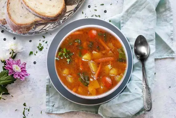 Top view of delicious homemade veggie soup and sourdough bread. 