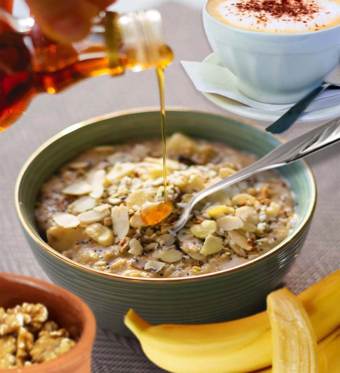 Close-up of a person pouring date syrup on a bowl of quinoa porridge. 