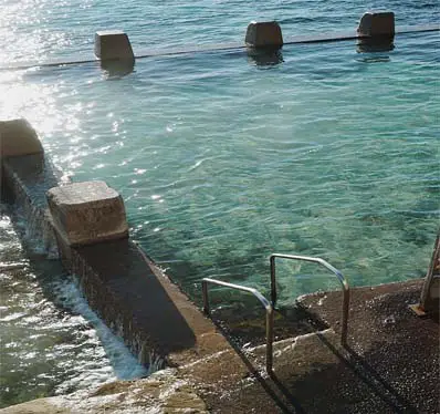 Concrete steps lead down into a cold outdoor lake.