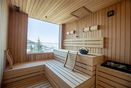 Interior of gorgeous wooden sauna with mountain view. 