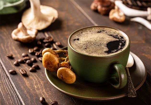 Foamy rich mug of organic infrared coffee on a rustic board with coffee beans and adaptogen mushrooms.  