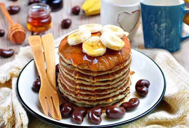 Huge stack of Himalayan Tartary Buckwheat pancakes with bananas, cacao, maple syrup.