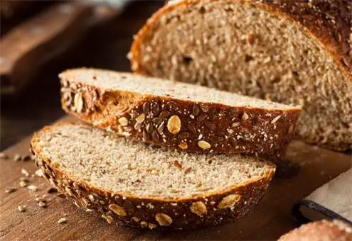 Close-up of Himalayan Tartary Buckwheat bread slices with seeded oat-flecked crust.   