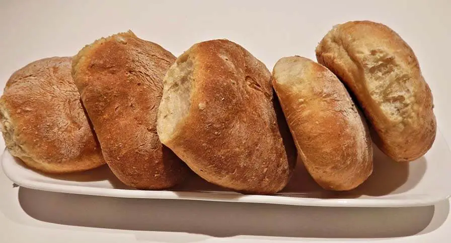 A long rectangular plate of rich vegan Himalayan Tartary Buckwheat dinner rolls. 