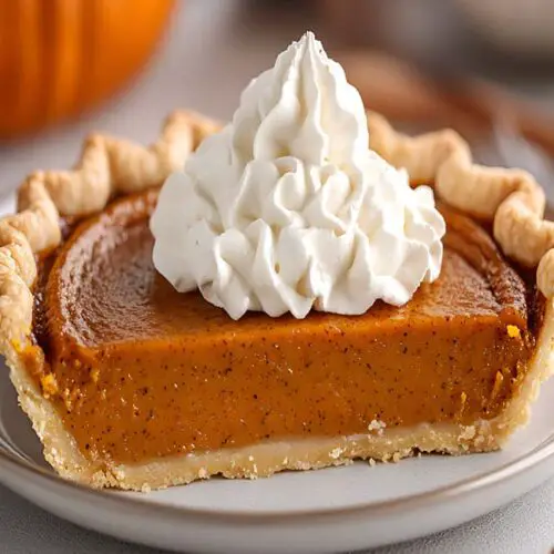 A succulent slice of organic gluten-free vegan pumpkin pie with coconut cream and spice.