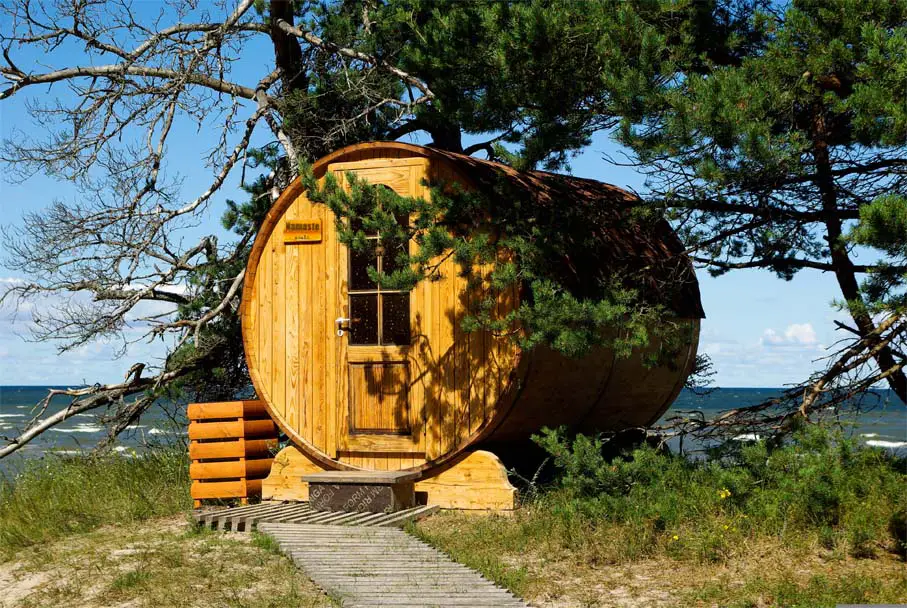 A gorgeous wooden barrel sauna overlooking the ocean surrounded by trees and sweeping views of the Northwest coast.