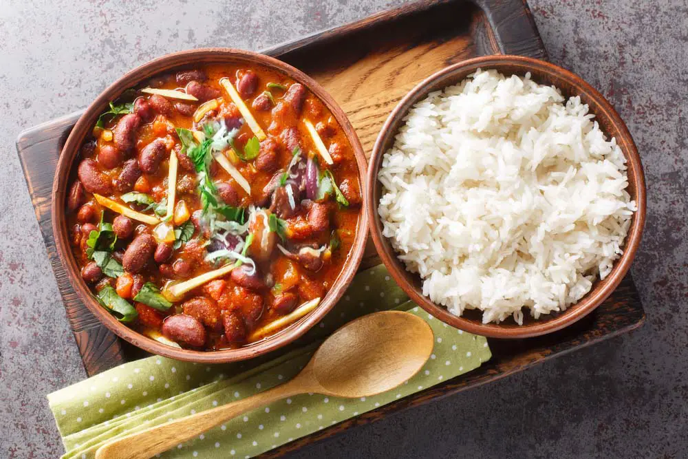 Looking down on a bowl of rich sprouted bean chili by a bowl of organic basmati rice. 