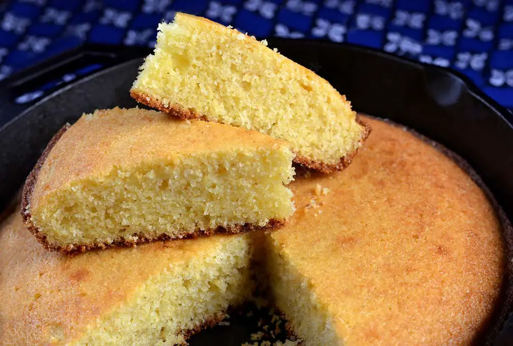 Close-up of moist cornbread slices on the loaf in a cast iron pan.  