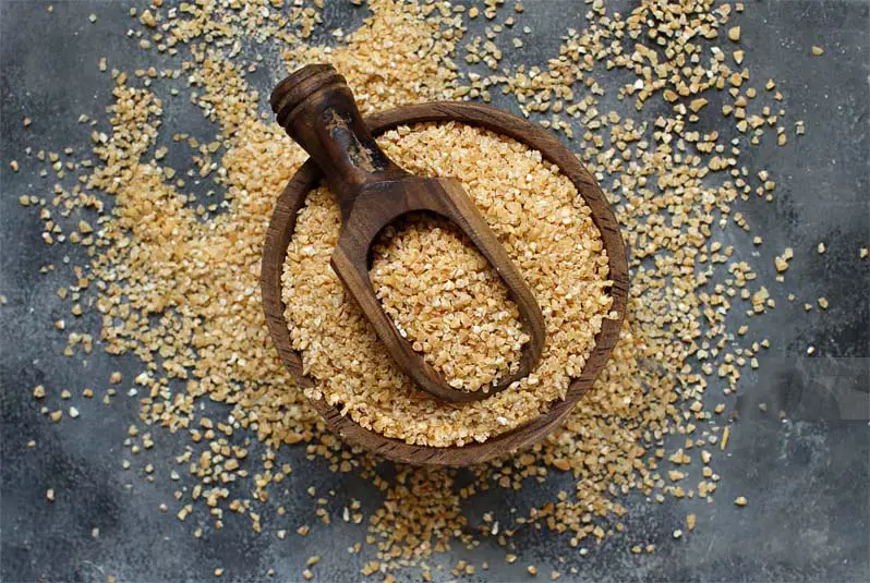 Top view of spermidine-rich wheatgerm in a rustic wooden bowl.