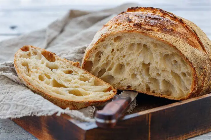 Sliced loaf of crusty homemade sourdough bread.  